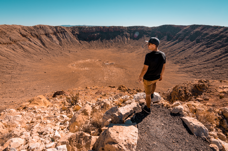 Man standing in front of giant crater